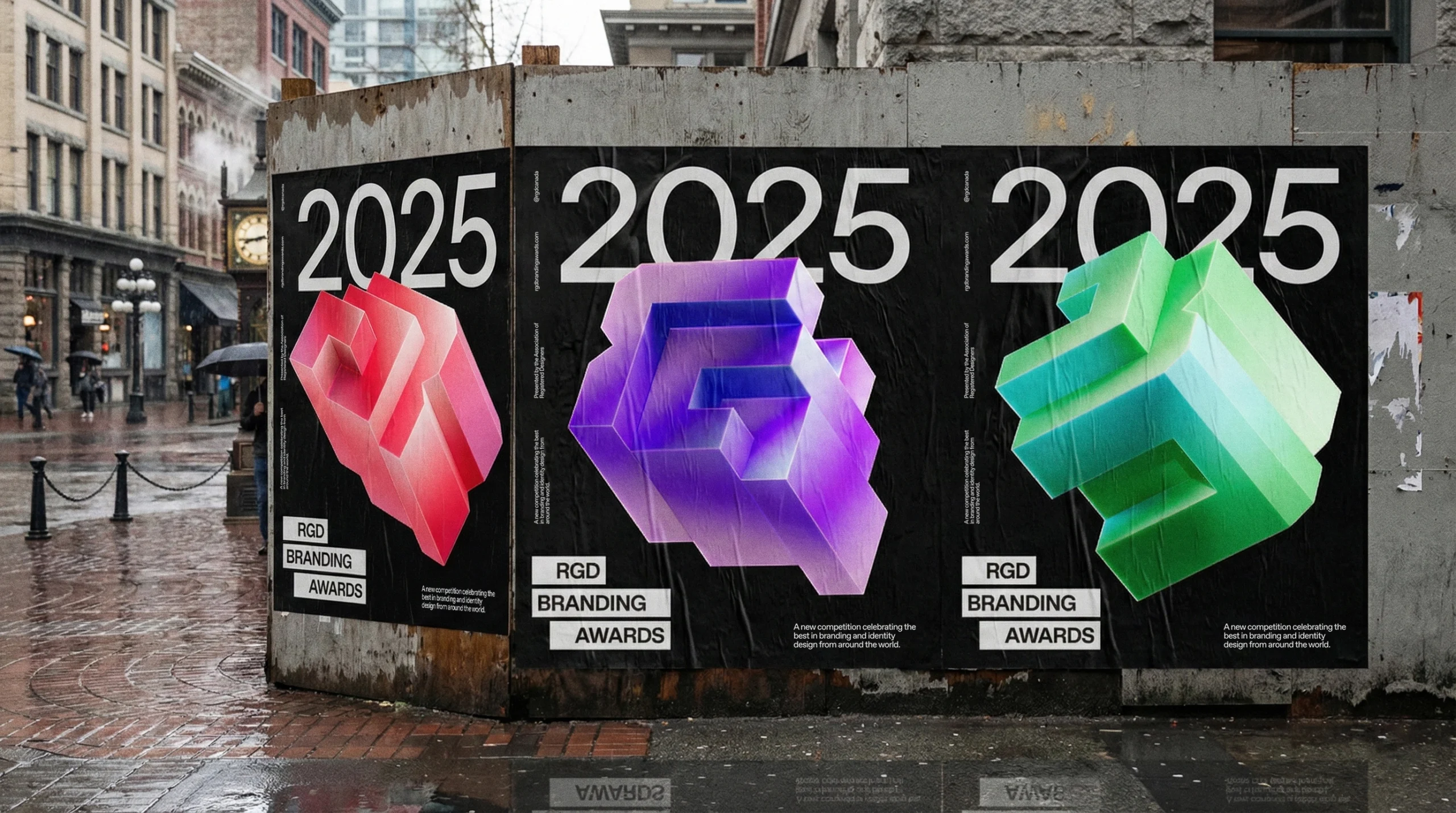 Urban wild posting campaign on a construction hoarding, featuring a sequence of R, G, and D posters in red, purple, and green 3D styles.